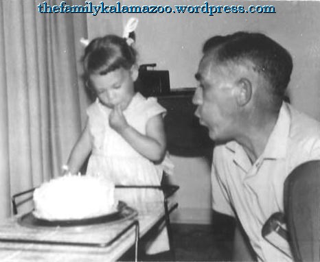 Grandpa helping 2-year-old me blow out the candles on my birthday cake